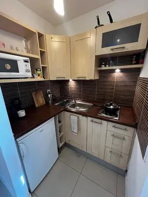 a small kitchen with a sink and a microwave at Cozy studio with Balcony & Parking in Kraków