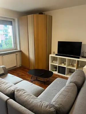 a living room with a couch and a flat screen tv at Cozy studio with Balcony & Parking in Kraków