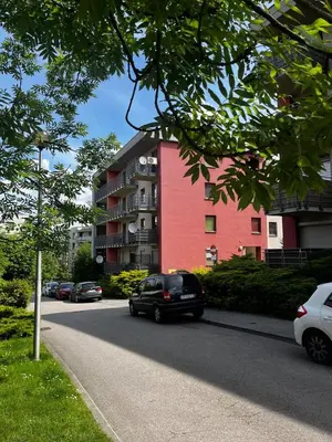 a black car parked in front of a red building at Cozy studio with Balcony & Parking in Kraków
