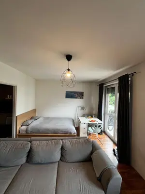a living room with a couch and a bed at Cozy studio with Balcony & Parking in Kraków