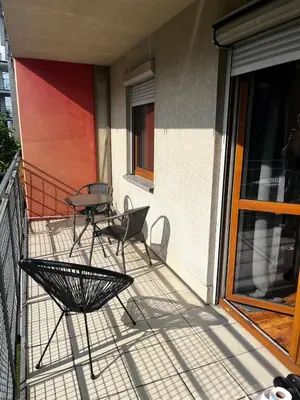 a patio with a table and chairs on a balcony at Cozy studio with Balcony & Parking in Kraków