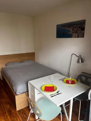 a bedroom with a bed and a white desk with two chairs at Cozy studio with Balcony & Parking in Kraków