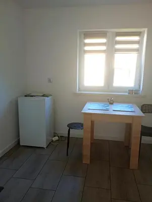 a room with a table and a refrigerator and a window at Agroturystyka u Pauliny in Sąspów