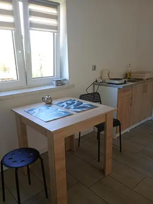 a kitchen with a wooden table and two chairs at Agroturystyka u Pauliny in Sąspów