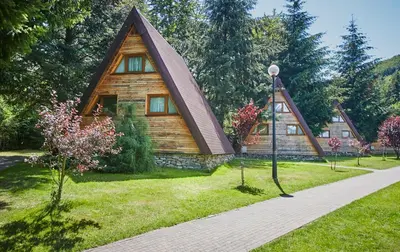 a small wooden house with a pointed roof at Domki Czarny Groń in Rzyki