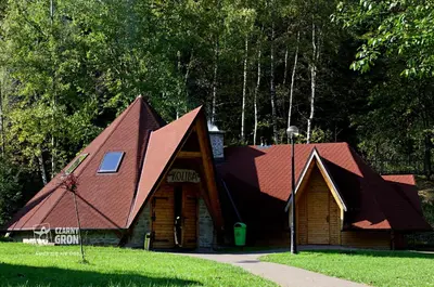 a house with a gambrel roof in a park at Domki Czarny Groń in Rzyki