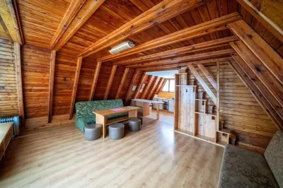 a wooden room with a chair and a table in it at Domki Czarny Groń in Rzyki