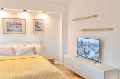a bedroom with a bed and a chair at Studio Lublańska - przytulne, nowoczesne, w klimacie Krakowa in Kraków