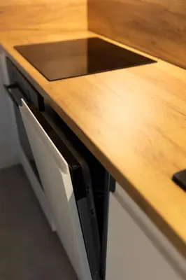 a kitchen counter with a wooden counter top at Studio Lublańska - przytulne, nowoczesne, w klimacie Krakowa in Kraków