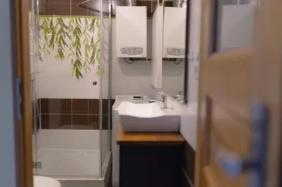 a bathroom with a sink and a shower and a mirror at Studio Lublańska - przytulne, nowoczesne, w klimacie Krakowa in Kraków