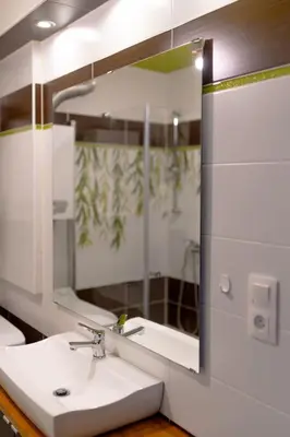 a bathroom with a sink and a large mirror at Studio Lublańska - przytulne, nowoczesne, w klimacie Krakowa in Kraków