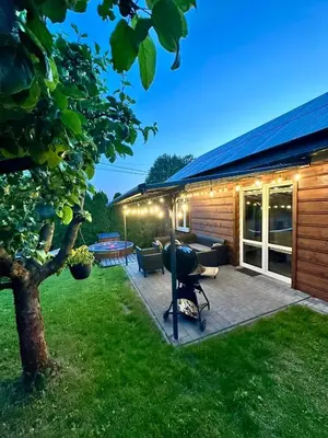 a house with a patio with a table and a tree at Domek nad Jeziorem Siamoszyce in Siamoszyce