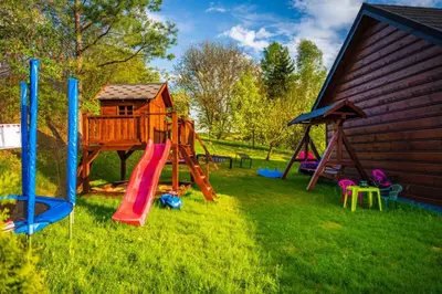 a playground with a slide and a play house at Domek nad Jeziorem Siamoszyce in Siamoszyce