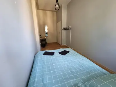 a bedroom with a blue bed with two black towels on it at Fantastic-Inn Kraków - KR6 in Kraków