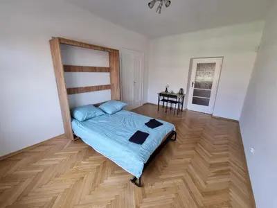 a bedroom with a bed and a wooden floor at Fantastic-Inn Kraków - KR6 in Kraków