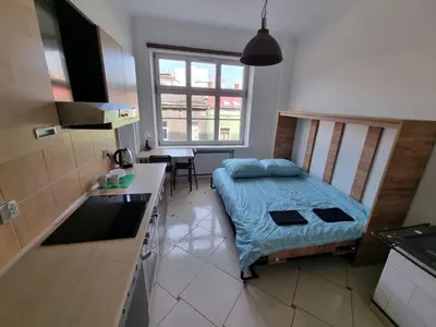 a small bedroom with a bed and a kitchen at Fantastic-Inn Kraków - KR6 in Kraków
