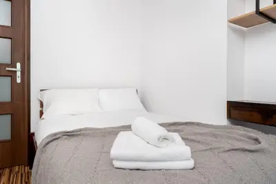 a bed with white towels on top of it at Komorowskiego Riverside Apartment by BookingHost in Kraków