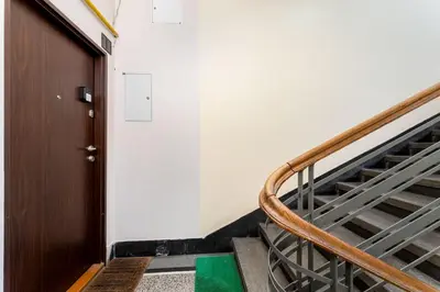 a staircase in a building with a wooden door at Komorowskiego Riverside Apartment by BookingHost in Kraków