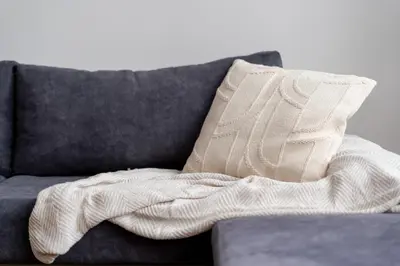 a blanket sitting on a couch with a pillow at Komorowskiego Riverside Apartment by BookingHost in Kraków