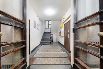 a hallway with wooden doors and a staircase at Komorowskiego Riverside Apartment by BookingHost in Kraków