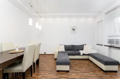 a dining room with a couch and a table at Komorowskiego Riverside Apartment by BookingHost in Kraków