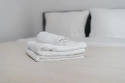 a stack of towels sitting on a counter in a bathroom at Komorowskiego Riverside Apartment by BookingHost in Kraków