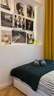 a bedroom with a bed and pictures on the wall at Golden Age Apartment Cracow in Kraków