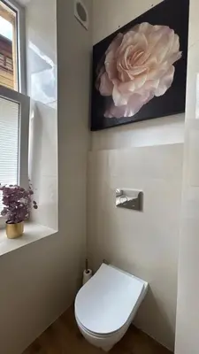 a bathroom with a toilet with a flower on the wall at Golden Age Apartment Cracow in Kraków