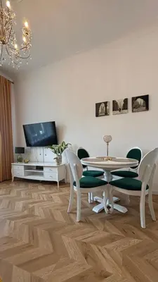 a living room with a table and chairs and a tv at Golden Age Apartment Cracow in Kraków
