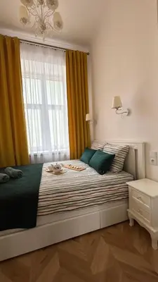 a bedroom with a bed with a large window at Golden Age Apartment Cracow in Kraków