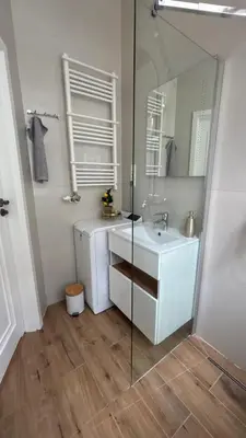 a bathroom with a white sink and a mirror at Golden Age Apartment Cracow in Kraków