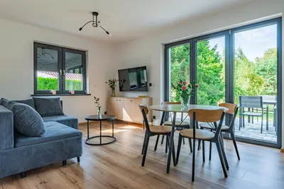 a living room with a couch and a table and chairs at Domek z Widokiem in Zator