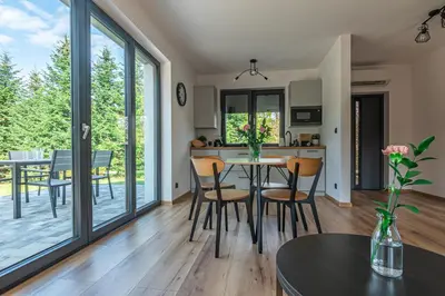 a kitchen and dining room with a table and chairs at Domek z Widokiem in Zator