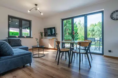 a living room with a table and chairs and a couch at Domek z Widokiem in Zator