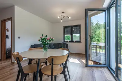 a dining room and living room with a table and chairs at Domek z Widokiem in Zator