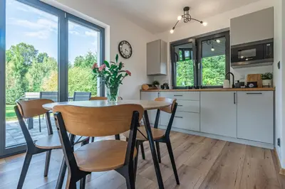 a kitchen and dining room with a table and chairs at Domek z Widokiem in Zator