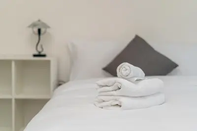 a pile of towels sitting on a bed at Osiedle Oświecenia Comfort Apartment by BookingHost in Kraków