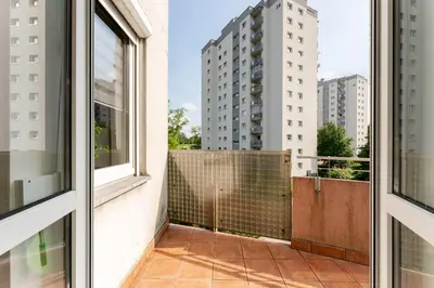 a balcony with a view of a building at Osiedle Oświecenia Comfort Apartment by BookingHost in Kraków