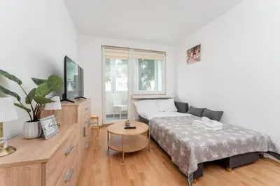 a bedroom with a bed and a tv and a couch at Osiedle Piastów Comfort Apartment by BookingHost in Kraków
