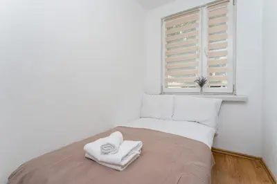 a bedroom with a bed with two towels on it at Osiedle Piastów Comfort Apartment by BookingHost in Kraków