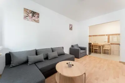 a living room with a couch and a table at Osiedle Piastów Comfort Apartment by BookingHost in Kraków