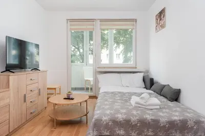 a bedroom with a bed and a tv and a table at Osiedle Piastów Comfort Apartment by BookingHost in Kraków