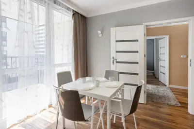 a white dining room with a white table and chairs at Beautiful Apartment Avia with balcony in Cracow city in Kraków