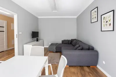 a living room with a couch and a table and chairs at Beautiful Apartment Avia with balcony in Cracow city in Kraków