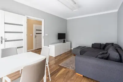 a white living room with a couch and a table at Beautiful Apartment Avia with balcony in Cracow city in Kraków