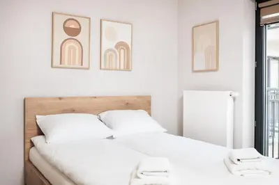 a bedroom with two beds and two pictures on the wall at City of the Kings - Corner 12 in Kraków