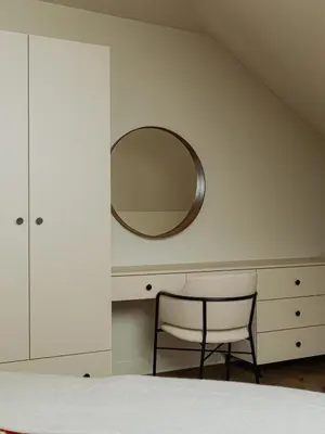 a bedroom with a chair and a mirror at Babiogórska Stodoła in Zawoja