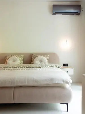 a bedroom with a large bed with a white wall at Babiogórska Stodoła in Zawoja