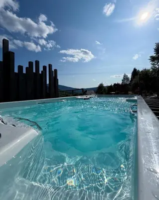 a large swimming pool with blue water at Babiogórska Stodoła in Zawoja
