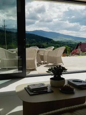 a group of white chairs sitting on a balcony at Babiogórska Stodoła in Zawoja